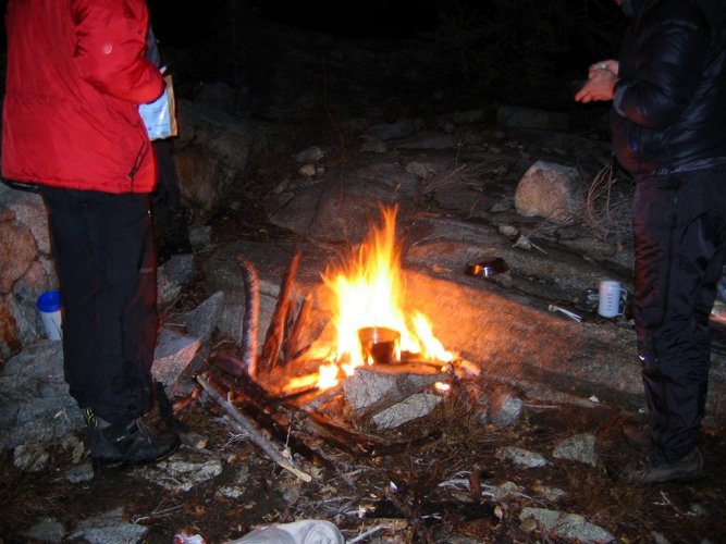 We had lost half our fuel due to a leak, so we decided to cook dinners over the fire.
Branches that have been rain-soaked for days are very hard to light.  We finally got the fire going by building a frame of branches and feeding it fir needles until the branches dried out enough to burn.
My poor, faithful pot was utterly blackened.